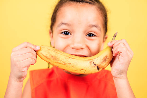 istock Yellow Background Child Banana 472153007