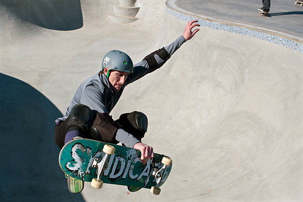 Veteran Skateboarder Catches Air In Bowl At New Skateboard Park Kennesaw, GA, USA - November 24, 2013:  A veteran skateboarder catches air in the bowl during "Old Man Sundays," as part of the grand opening weekend of the brand new Kennesaw Skateboard Park. elbow pad stock pictures, royalty-free photos & images