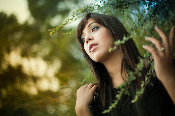 istock Beautiful young woman in nature looking away. 472155135