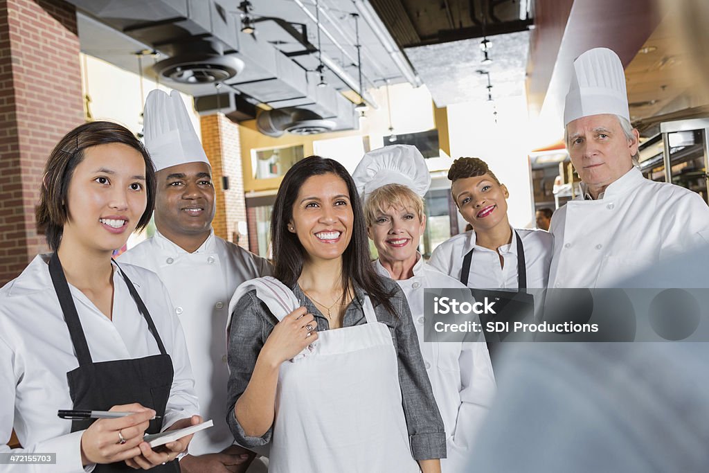 Restaurante chefs y waitstaff obtener instrucciones del gerente en la cocina - Foto de stock de Chef libre de derechos