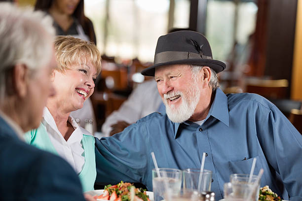 istock Senior couple having dinner with friends in modern restaurant 472155915