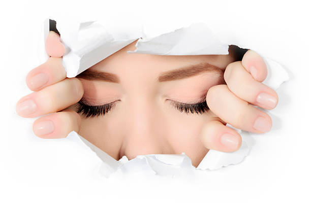 istock woman eyes closed through torn paper 472155941