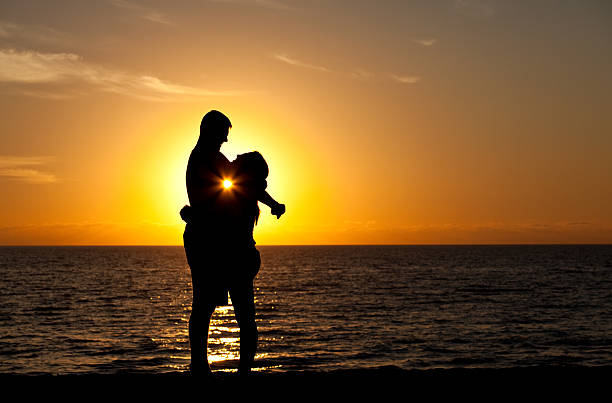 istock Young Couple Embracing at Sunset 472156305