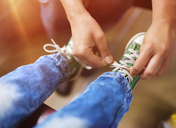 Father and son in train Father tying shoe laces of his son traveling in train. in bounds stock pictures, royalty-free photos & images