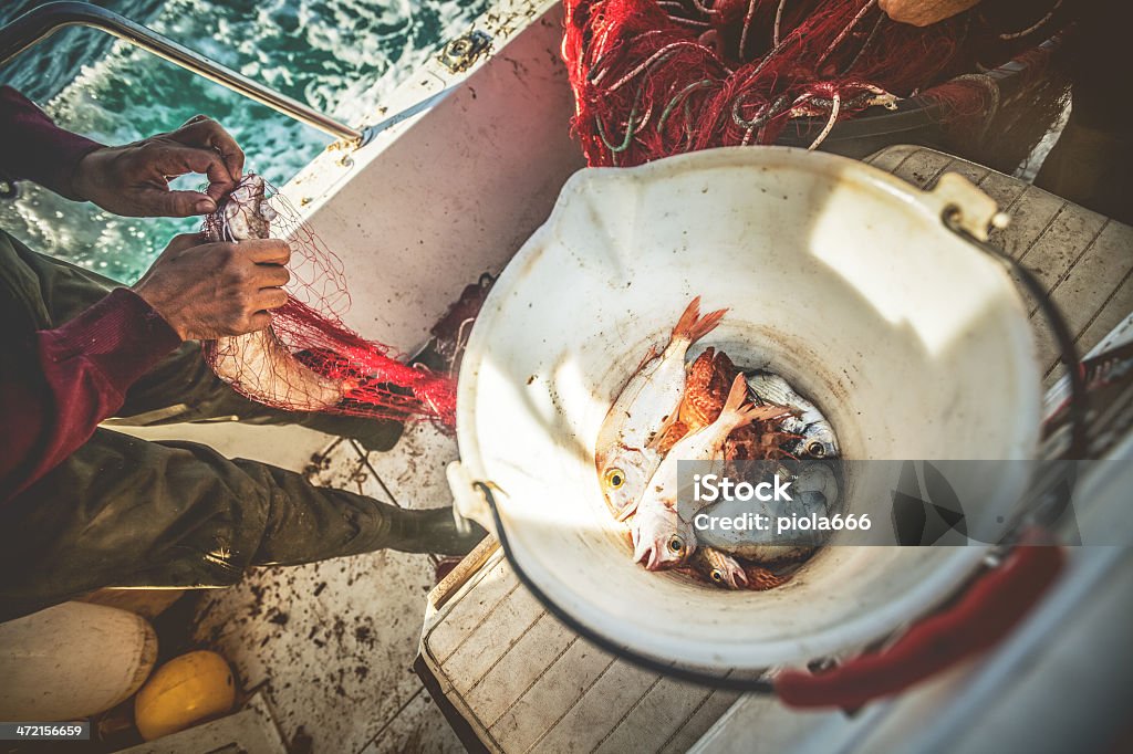 Os pescadores no trabalho, limpeza das redes - Foto de stock de Adulto royalty-free