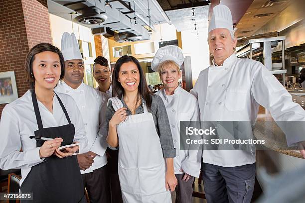 Professional Chefs And Waitstaff Meeting With Manager In Restaurant Kitchen Stock Photo - Download Image Now