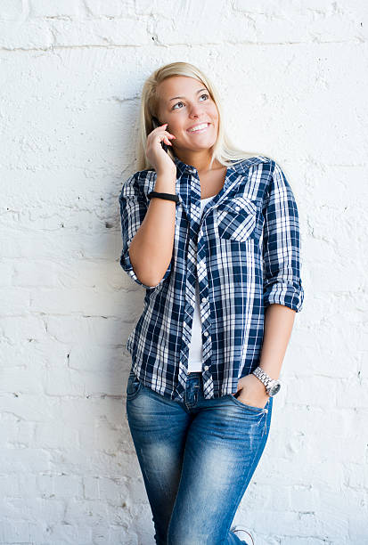 istock Beautiful young woman using a cell phone 472157127
