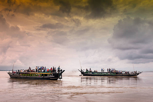 Ferries cross the Brahmaputra, Assam, India. Jorhat, India - August 23, 2011: Public ferries cross the Brahmaputra river crowed with passengers leaving for and returning from Majuli island on August 23, 2011 near Jorhat, Assam, India. brahmaputra river stock pictures, royalty-free photos & images