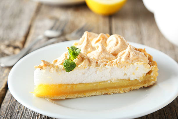 istock Lemon meringue pie on plate on grey wooden background 472159238