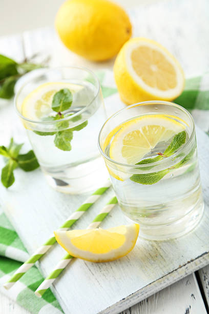 istock Fresh lemonade with lemon on white wooden background 472159246