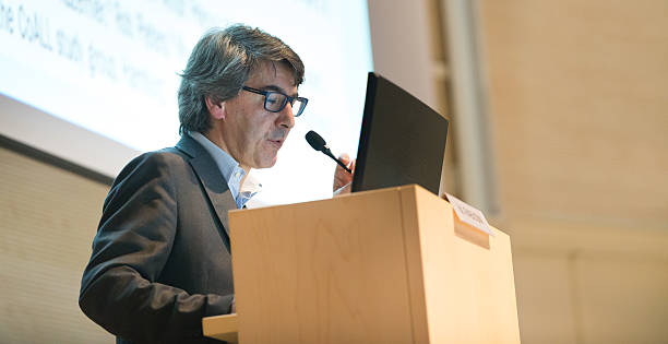 istock A man at a podium speaks at a business conference 472159528