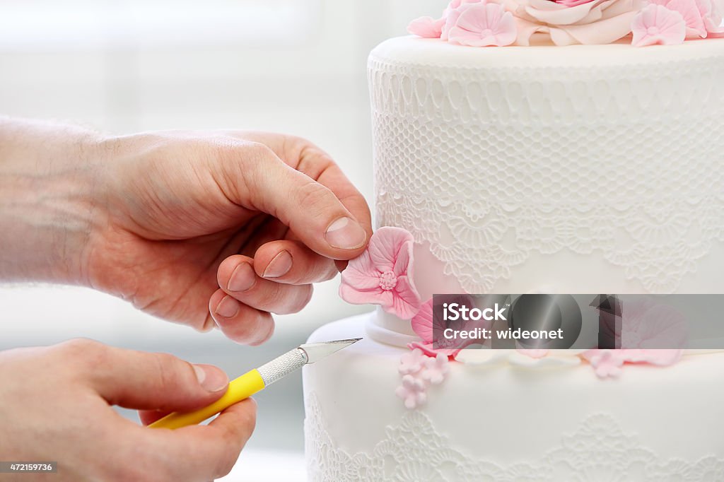 Confectioner decorates wedding cake - 免版稅蛋糕圖庫照片