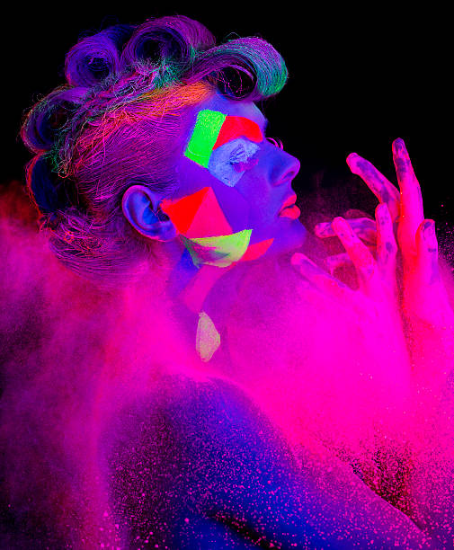 istock Women Portrait with Glowing makeup in black light 472160361