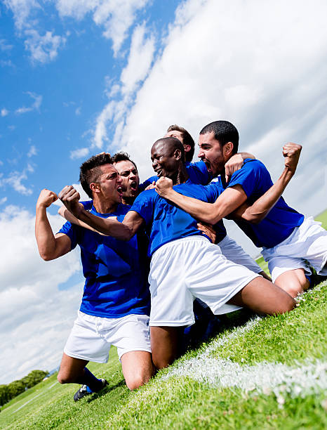 Football team celebrating a goal at the soccer field