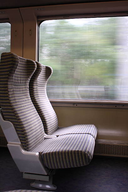 istock Photo of two empty side-by-side seats on a moving train  472161915