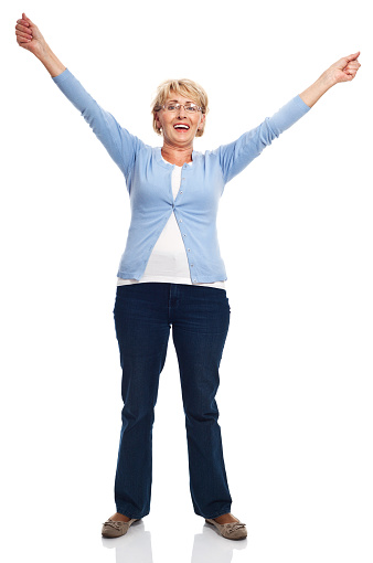 Full lenght portrait of happy senior woman standing with raised hands. Studio shot, white background.
