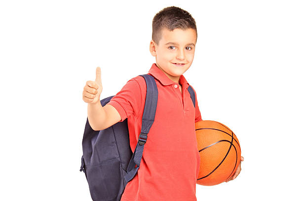 istock School boy with backpack holding basketball and giving thumb up 472163291