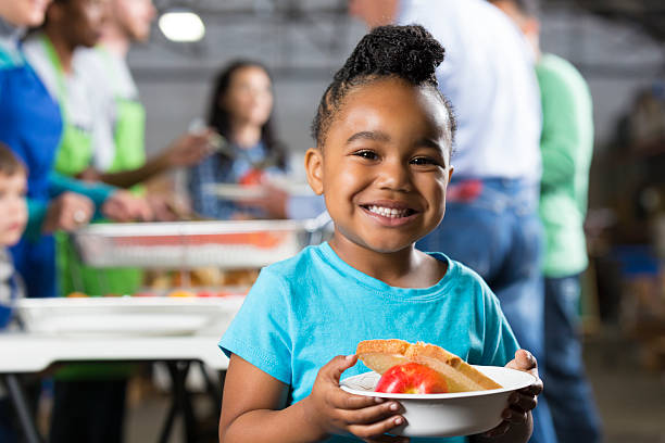Little girl holding bowl at soup kitchen or food bank Little girl holding bowl at soup kitchen or food bank. food staple stock pictures, royalty-free photos & images