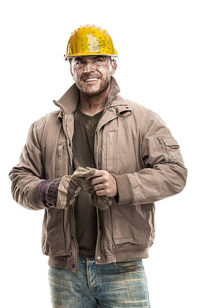 Young dirty Worker Man With Hard Hat helmet Young dirty Worker Man With Hard Hat helmet  holding a work gloves and smiling isolated on White Background Impurities stock pictures, royalty-free photos & images