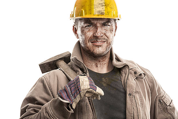Young dirty Worker Man With Hard Hat helmet  holding a hammer and smiling isolated on White Background
