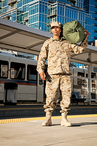 US Marine soldier with a duffle bag at the train station. The model is wearing an official US Marine corps Marpat BDU uniform.