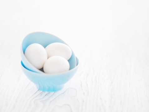 White eggs in blue bowl ready to be coloured for Easter