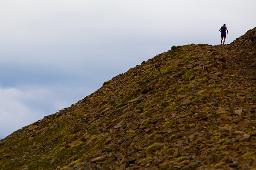 A man competes in a long distance trail running race.