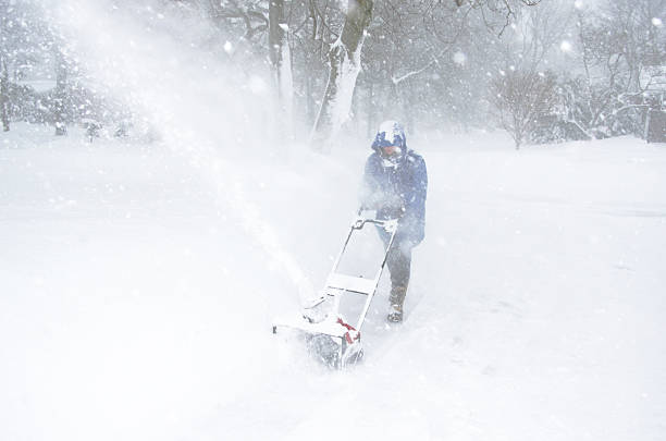 snowblowing during a storm stock photo