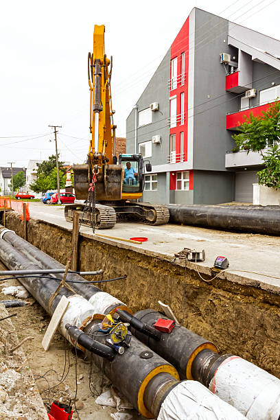 istock Yellow excavator at construction site in urban settlement 472167698