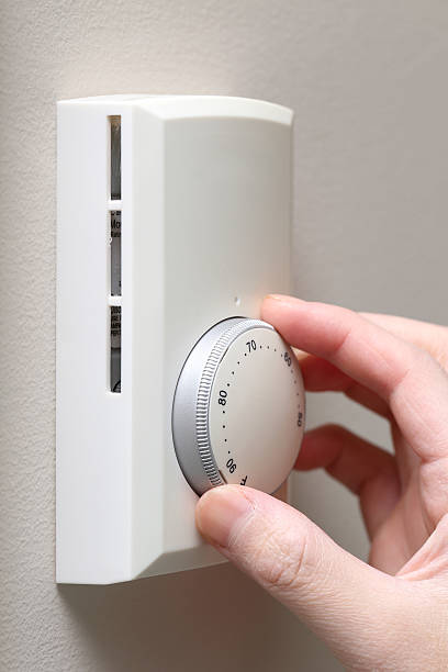 istock Woman hand rotating climate control 472167999