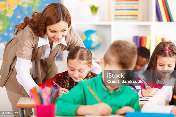 Teacher Helping Students Stock Photo - Download Image Now - 8-9 Years, A Helping Hand, Adult