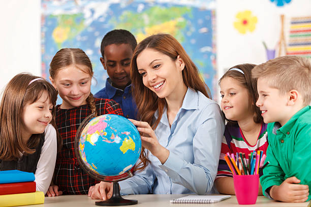 Teacher and children looking at globe