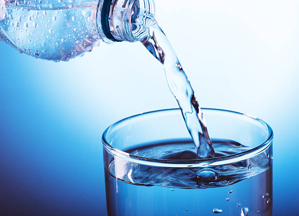 istock Pouring water from bottle into glass 472170347