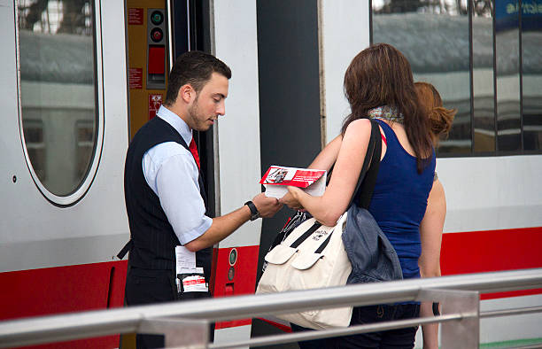 Train Conductor checks Tickets Cologne, Germany - August 30, 2013: Train conductor checks the tickets of female travelers on an international train in the railway station of Cologne, Germany on August 30, 2013 transport conductor stock pictures, royalty-free photos & images