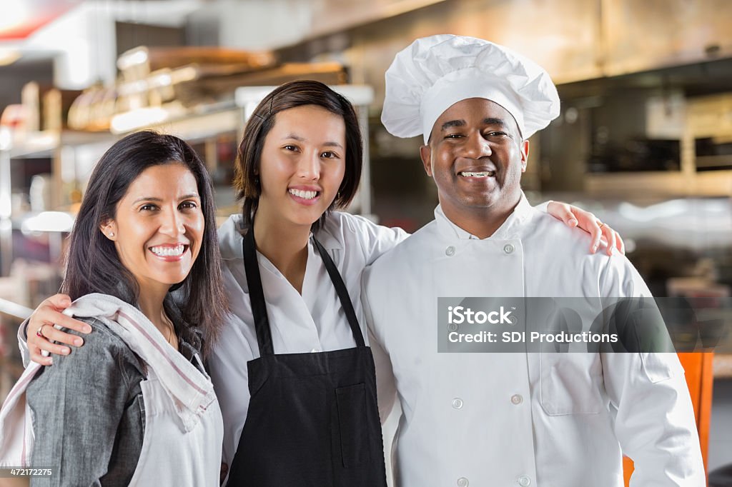 Diverse team of chefs and waitstaff in modern restaurant kitchen 30-39 Years Stock Photo