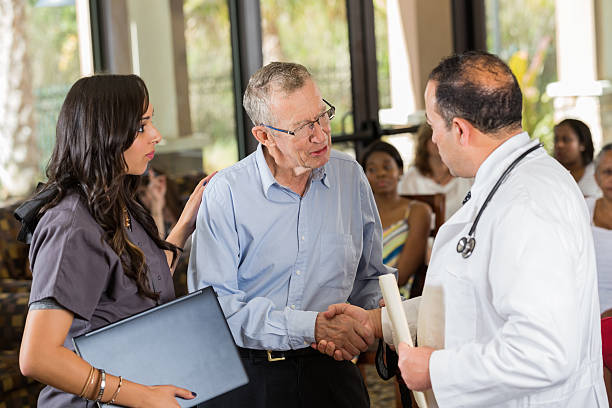 istock Doctor and patient shaking hands at wellness fair 472172291
