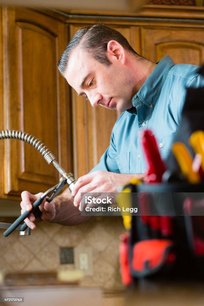 Home Repairman A repairman with tools working in a kitchen. 30-39 Years Stock Photo