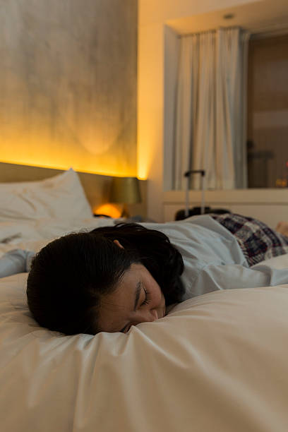 istock tired businesswoman on bed 472175973