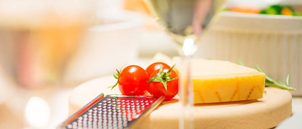 Fresh tasty hard parmesan cheese on a wooden board with grater.