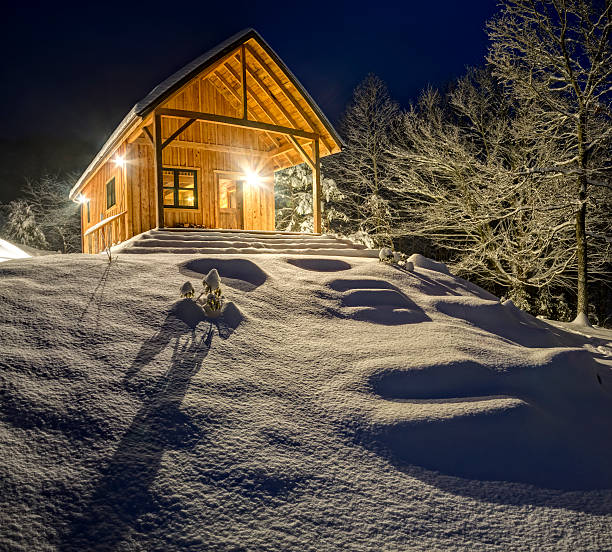 istock Rustic cabin in winter blizzard snowstorm at night 472176969