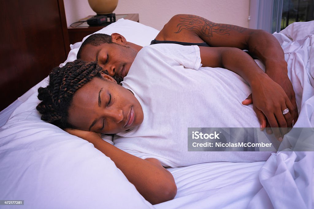 Grávida americano africano preto Dormir abraçados em cama de casal - Foto de stock de Afro-americano royalty-free