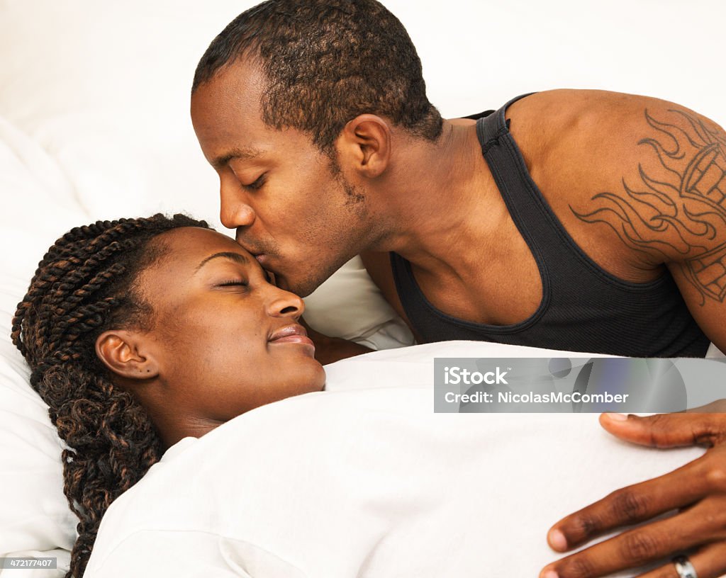 Afryki amerykański czarny człowiek delikatnie mieć w ciąży żona w łóżku - Zbiór zdjęć royalty-free (20-29 lat)