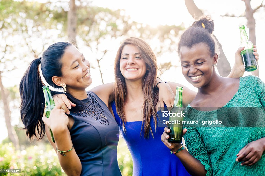 Three young women having fun at the park Three young women relaxing at the park, drinking beers. 18-19 Years Stock Photo