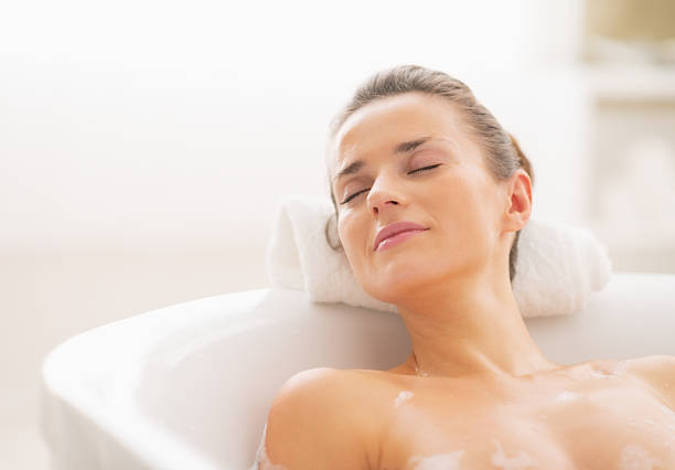 istock relaxed young woman in bathtub 472177595