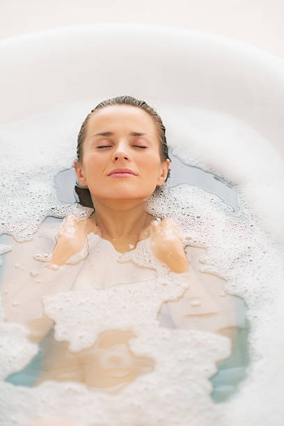 istock young woman laying in bathtub 472177609