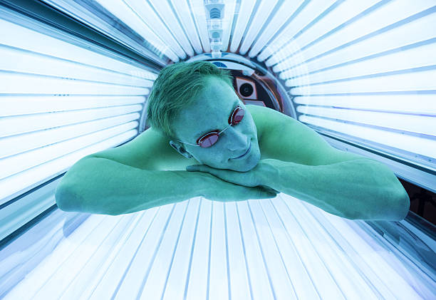 Man with sunglasses on tanning bed in solarium Man with sunglasses on tanning bed in solarium tanning bed stock pictures, royalty-free photos & images