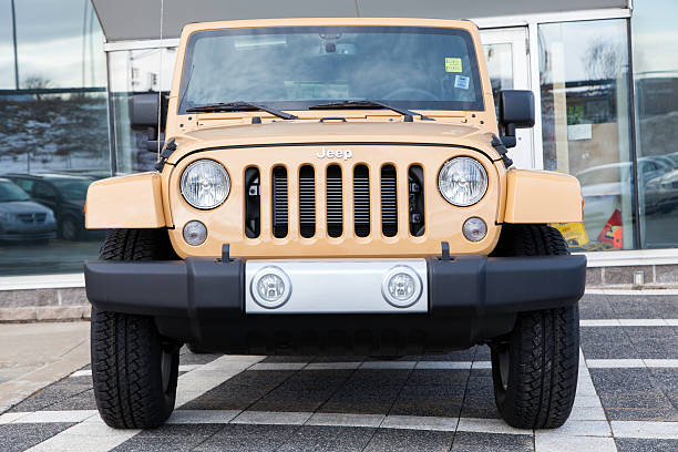 Dartmouth, Nova Scotia, Canada - February 23, 2014: A Jeep Wrangler Unlimited Sahara parked in front and on display at a car dealership.  The vehicle entrance is visible behind vehicle and other Dodge vehicles are visible in a row on other side of dealership.