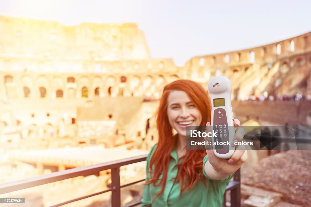 tourist with phone in Colloseum happy tourist with phone to listen guide indication, showing it. vacation and having fun, relax and enjoy her time. 2015 Stock Photo