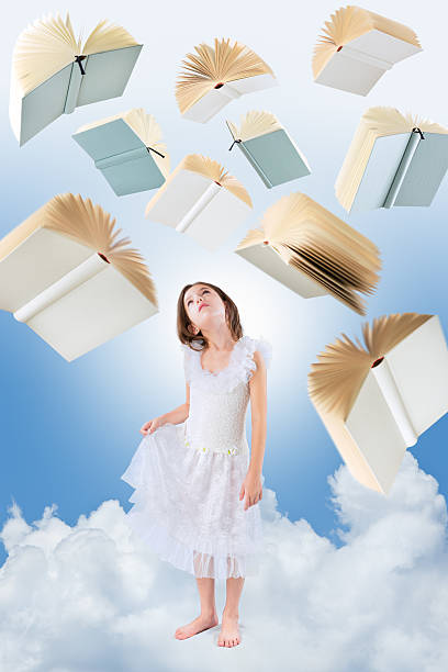 istock Flying books over little girl looking up 472180801