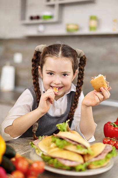 istock Little girl eating sandwich. 472181625